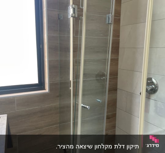 דלת זכוכית למקלחת עם ידיות מתכת